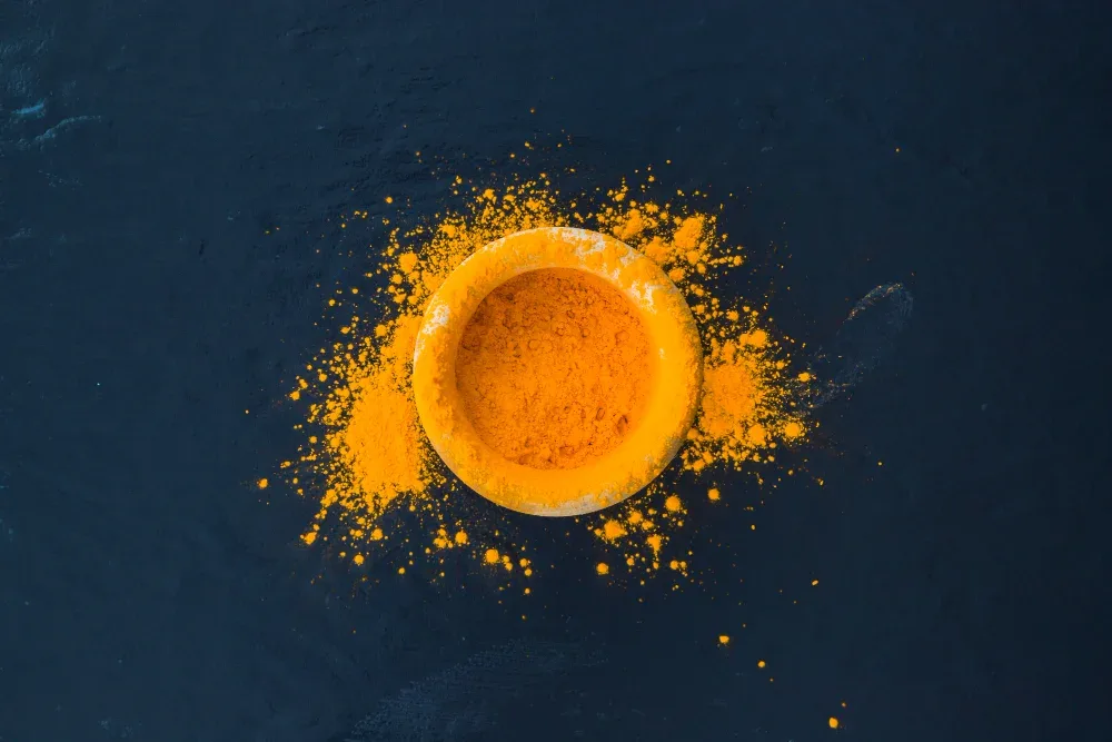 Close-up of turmeric powder, and a label highlighting curcumin content